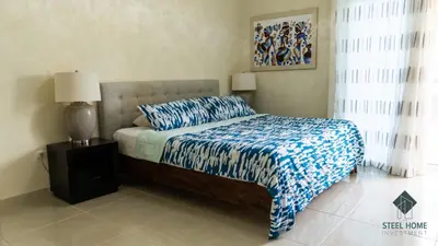 a bedroom with a bed with a blue and white bedspread at Eden Caribe Punta Vana in Punta Cana