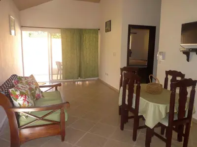 a living room with a table and chairs and a television at Villa near the beach in Cabarete