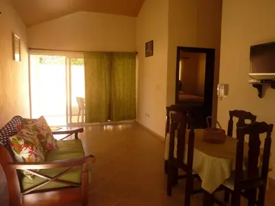 a living room with a table and chairs and a television at Villa near the beach in Cabarete