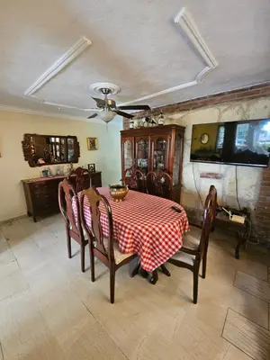 a dining room with a table and chairs and a tv at Villa Mila en Santo Domingo in Los Tres Ojos de Agua