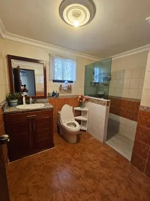 a bathroom with a toilet and a shower and a sink at Villa Mila en Santo Domingo in Los Tres Ojos de Agua
