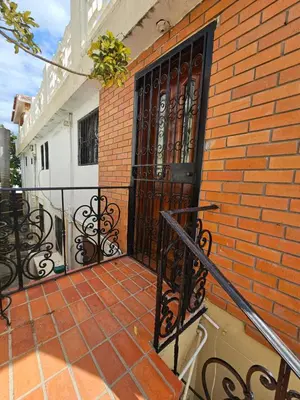 a black door on a brick building with a brick sidewalk at Villa Mila en Santo Domingo in Los Tres Ojos de Agua