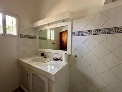 a white bathroom with a sink and a mirror at Casa Siete Las Terrenas in Las Terrenas