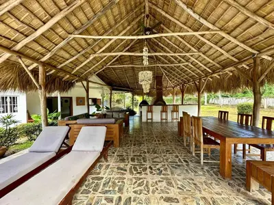 a pavilion with wooden tables and chairs and a dining area at Casa Siete Las Terrenas in Las Terrenas