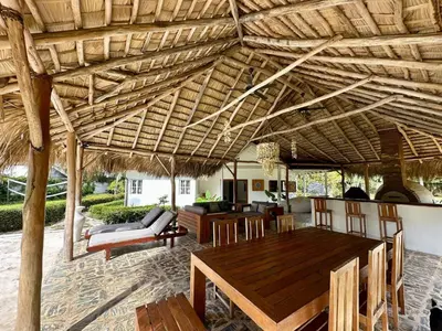an outdoor dining room with a wooden ceiling with a table and chairs at Casa Siete Las Terrenas in Las Terrenas