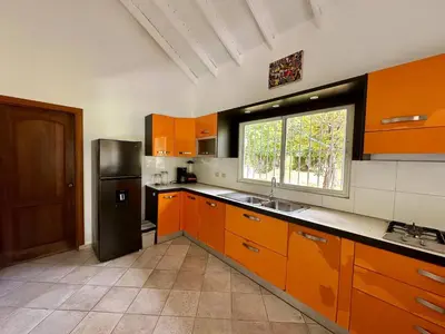 a kitchen with orange cabinets and a black refrigerator at Casa Siete Las Terrenas in Las Terrenas