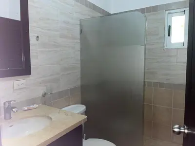 a bathroom with a shower and a toilet and a sink at Villa amalu in Cabarete