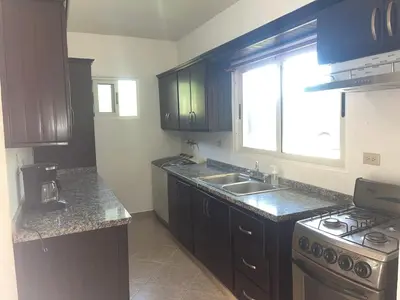 a kitchen with wooden cabinets and a sink and a stove at Villa amalu in Cabarete