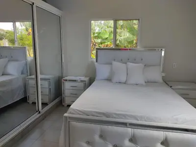 a bedroom with a bed with white sheets and pillows at Hermosa casa de campo in Juana Vicenta