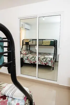 a mirror with a reflection of a bed in a room at vacation apartment BANI PERAVIA in Boca Canasta