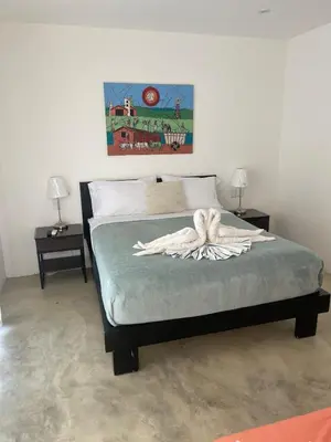 a bed in a bedroom with two nightstands and two lamps at Villa Mirna in Las Terrenas