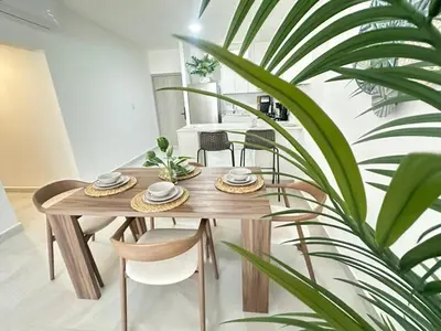 a wooden table with two chairs and a plant at A104 - PRADOS · Peaceful 2BR Poolside Retreat • Punta Cana Getaway in Punta Cana