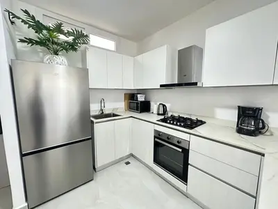 a kitchen with white cabinets and a stainless steel refrigerator at A104 - PRADOS · Peaceful 2BR Poolside Retreat • Punta Cana Getaway in Punta Cana
