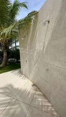 a concrete wall with a palm tree behind it at A104 - PRADOS · Peaceful 2BR Poolside Retreat • Punta Cana Getaway in Punta Cana