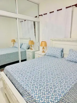 a bedroom with two beds and a mirror at Comfortable and warm apartment in Higuey