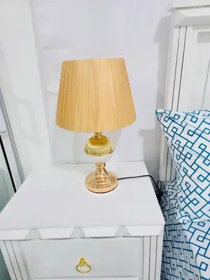 a lamp on a white nightstand next to a bed at Comfortable and warm apartment in Higuey