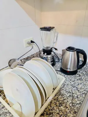 a kitchen counter with plates and a blender on it at Comfortable and warm apartment in Higuey
