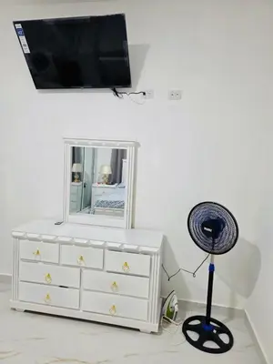 a white dresser with a mirror and a fan at Comfortable and warm apartment in Higuey