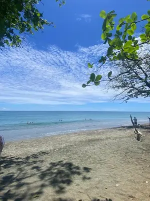 a beach with people swimming in the ocean at A space designed for you in San Cristóbal