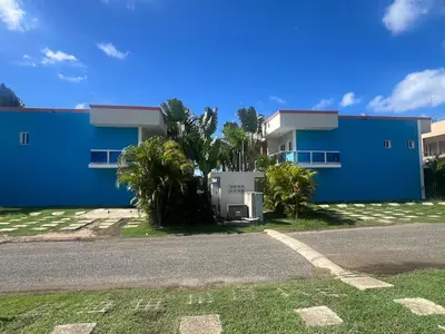 a blue building with palm trees in front of it at Quiet and beautiful view in Boca Chica