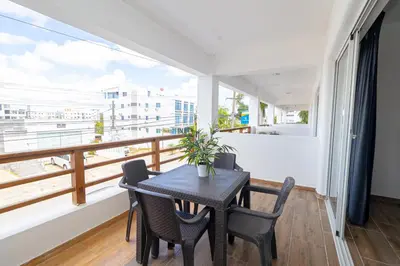 a dining room with a table and chairs and a balcony at Luxury 1 BR at Paraiso Residence Bayahibe in Bayahibe