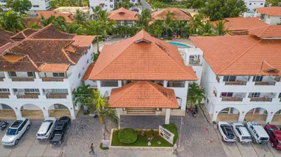 an aerial view of a building with cars parked in a parking lot at Luxury 1 BR at Paraiso Residence Bayahibe in Bayahibe