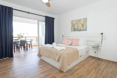 a bedroom with a bed and a dining room at Luxury 1 BR at Paraiso Residence Bayahibe in Bayahibe