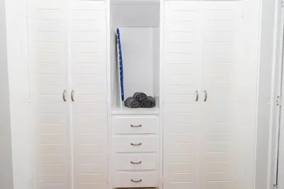 a white closet with white cabinets and a mirror at Luxury 1 BR at Paraiso Residence Bayahibe in Bayahibe