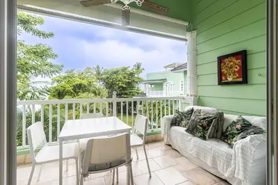 a porch with a couch and a table and chairs at Galeria Beach Front, Top floor in Sosúa