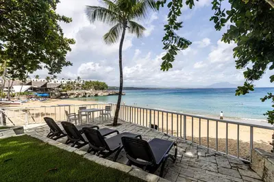 a row of chairs sitting next to a beach at Galeria Beach Front, Top floor in Sosúa