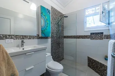 a bathroom with a toilet and a sink and a shower at Galeria Beach Front, Top floor in Sosúa
