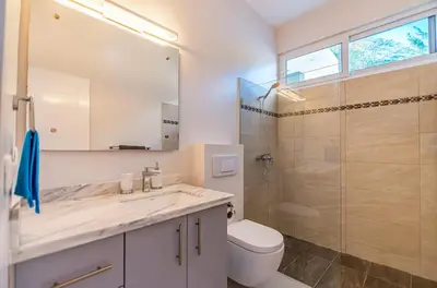 a bathroom with a toilet sink and a shower at Villa real con piscina panorámica para más de 14 huéspedes in Sosúa