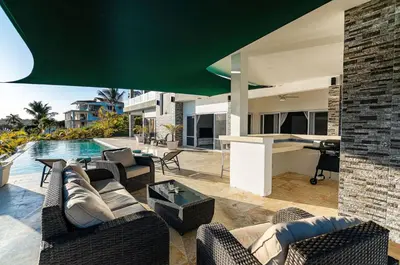 a living room with a pool and a house at Villa real con piscina panorámica para más de 14 huéspedes in Sosúa