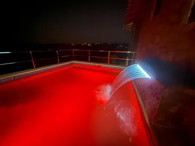 a person holding a book on a balcony at night at Casa vista hermosa in Camú