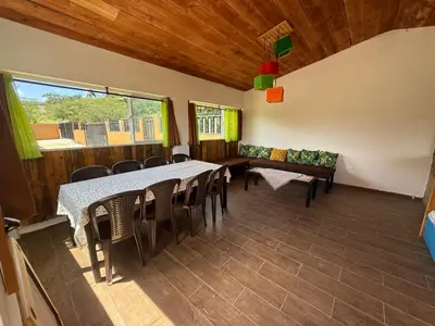 a dining room with tables and chairs and a window at Casa vista hermosa in Camú