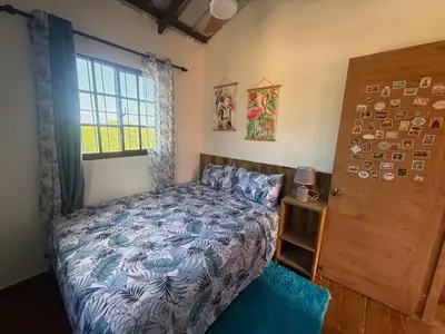 a bedroom with a bed and a window and a door at Casa vista hermosa in Camú