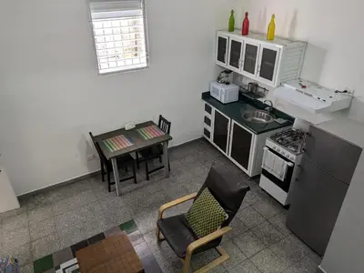 a kitchen with a table and a chair and a stove at Espacio Santa Bárbara, Zona Colonial in Santo Domingo