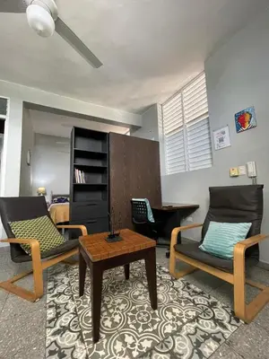 a living room with two chairs and a coffee table at Espacio Santa Bárbara, Zona Colonial in Santo Domingo