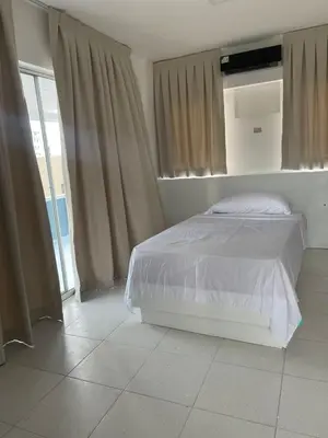 a bedroom with a bed and a large window at Zile Hotel in Boca Chica