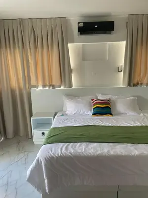 a bedroom with a white bed with a colorful pillow at Zile Hotel in Boca Chica
