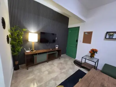 a living room with a television and a green door at Playa y arena in San Felipe de Puerto Plata