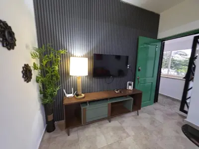 a room with a desk with a lamp and a television at Playa y arena in San Felipe de Puerto Plata
