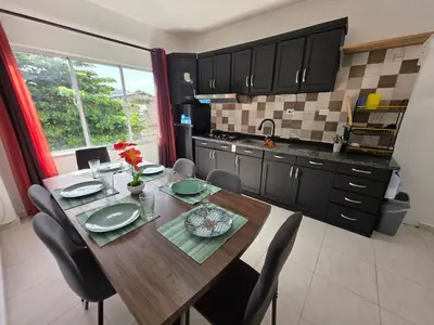 a kitchen with a wooden table with chairs and a dining room at Brisa de mar in San Felipe de Puerto Plata