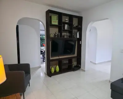a living room with a flat screen tv on a shelf at Brisa de mar in San Felipe de Puerto Plata