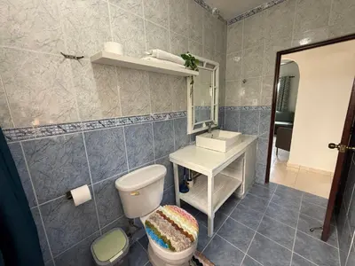 a bathroom with a toilet and a sink and a mirror at Brisa de mar in San Felipe de Puerto Plata
