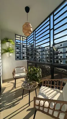 a balcony with two chairs and a table and windows at Apartamento en La Romana 3 habitaciones in La Romana