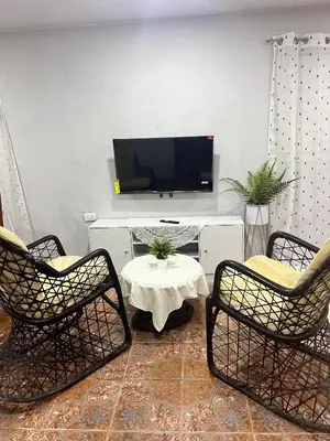 a living room with two chairs and a table and a tv at La Casita in Vicente Noble