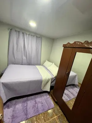 a small bedroom with a bed and a mirror at La Casita in Vicente Noble