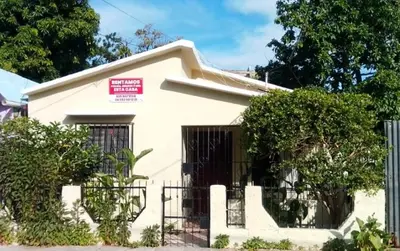 a white house with a sign in front of it at La Casita in Vicente Noble