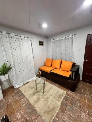 a black couch with orange pillows in a living room at La Casita in Vicente Noble